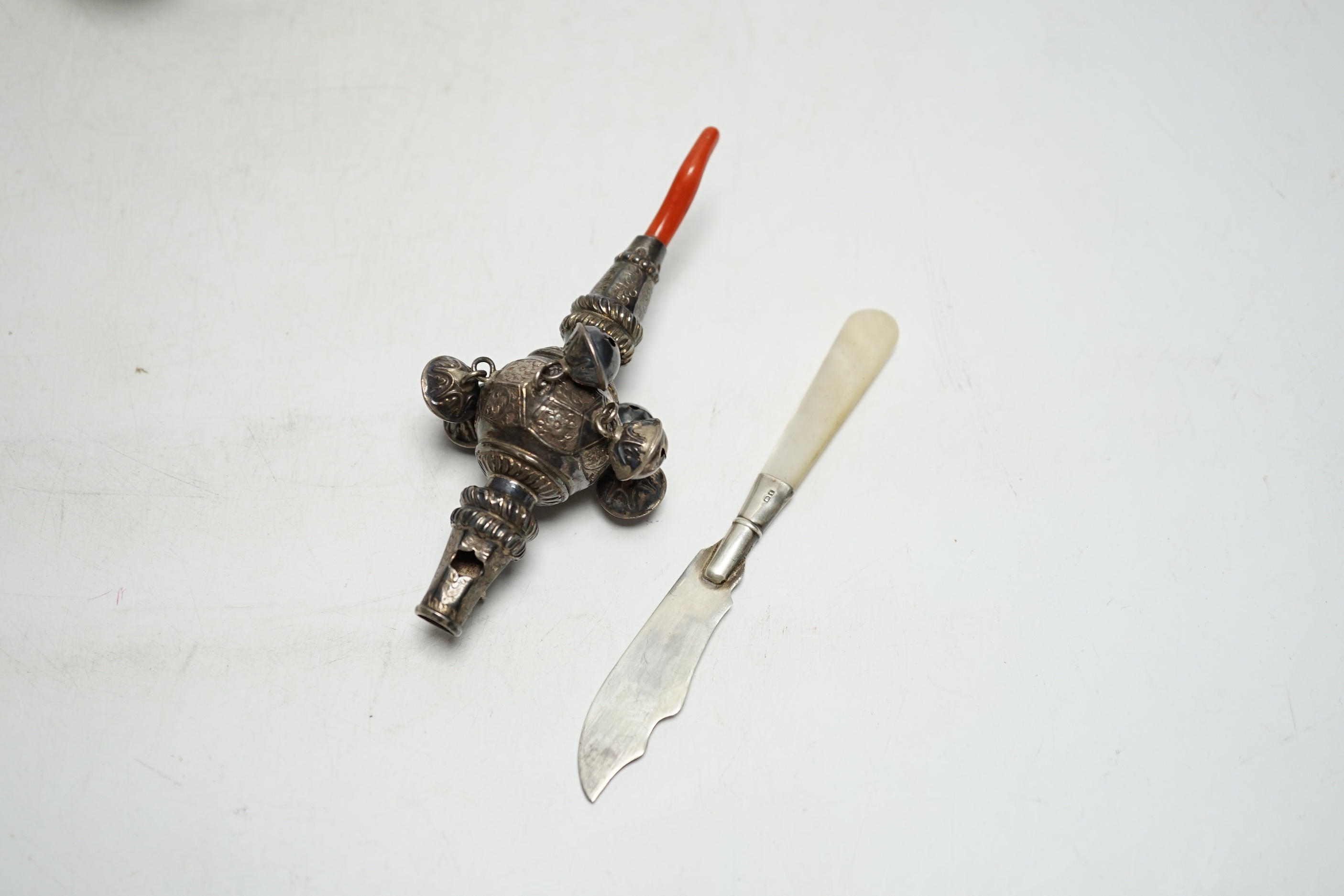 A late Victorian silver baby rattle, with coral teether, by George Unite, 11.6cm and a small silver butter knife.